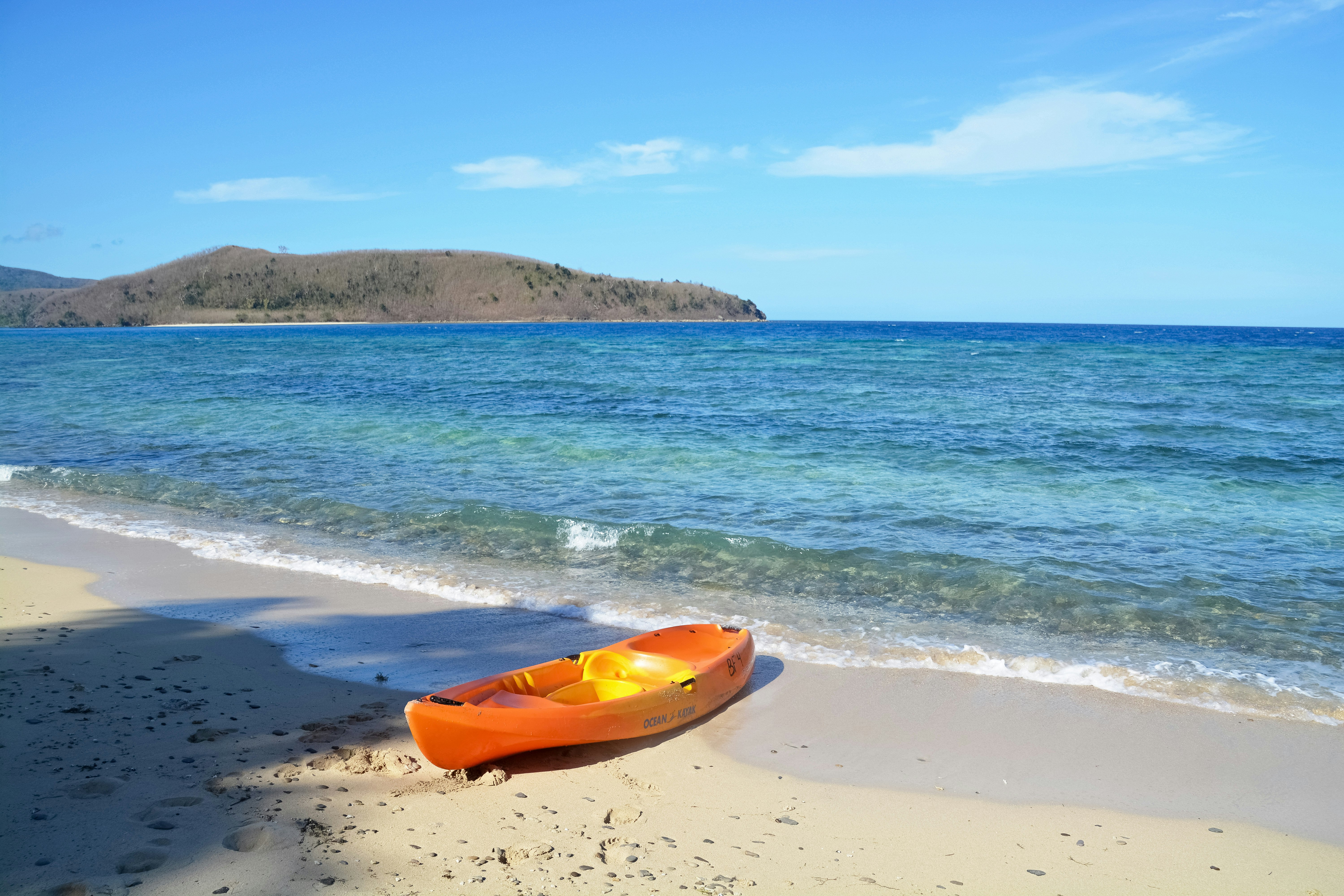 orange kayak on beach during daytime